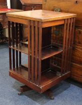 An early 20th century two tier revolving bookstand on swivel base with castors 86cm high (a/f)