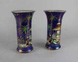 A pair of Carlton Ware Persian pattern cylindrical vases decorated with a temple within gilded