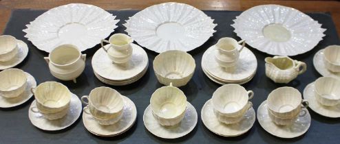 A Belleek porcelain Tridacna pattern part tea service comprising three platters, fourteen tea cups