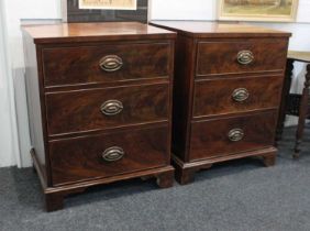 A pair of small mahogany chests of three drawers, with oval drop handles on bracket feet, 53cm