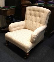 A Howard style button back upholstered armchair on turned front legs and castors