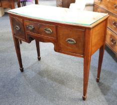 An Edwardian mahogany kneehole dressing table with an arrangement of three drawers on square tapered