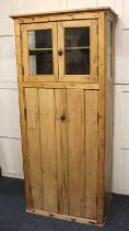 A pine glazed cupboard with glazed top compartment above vertical slatted cupboard doors, 79cm
