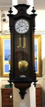 A Vienna style wall clock with white enamel dial, two brass weights and pendulum in ebony lined