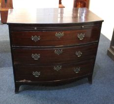 A 19th century mahogany bowfront chest of three graduated drawers below a brushing slide above a