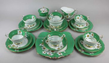 A Paragon porcelain 'Narcissus' pattern part tea service with green border, comprising sugar pot and