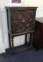 An oak cabinet with geometric panelled door on spiral turned supports and stretchers, 65cm