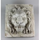 A decorative relief moulded plaster plaque depicting a lion mask on a square base and clipboard