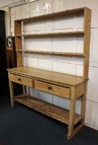 A pine dresser with open two shelf plate rack, the base with two drawers and under-tier 159cm (a/f)