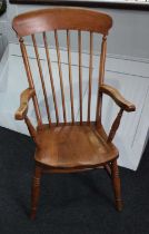 A farmhouse kitchen armchair spindle back and solid seat on turned legs