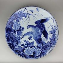 A Japanese blue and white porcelain charger decorated with a bird of prey amongst flowers and