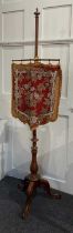 A 19th century walnut pole screen featuring decorative glass beadwork on a wool work shield shaped