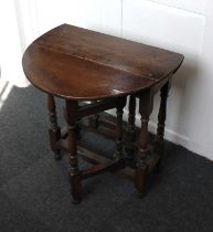 An oak small drop leaf side table with block and turned gateleg supports, opens to 70cm