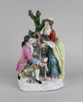 A Chelsea-style porcelain figure group of a gentleman and lady examining ribbons, gold anchor mark