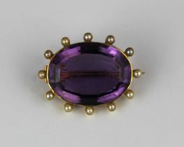 A gold, amethyst and half pearl oval brooch collet set with the oval cut amethyst at the centre