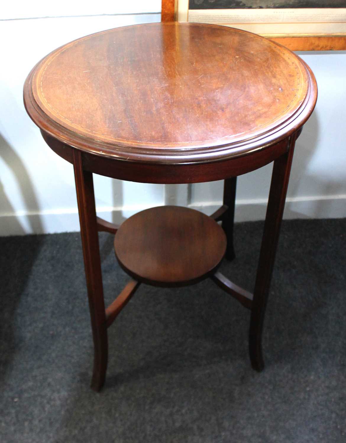 An Edwardian inlaid mahogany circular two tier side table, c.1900/1910, raised on elegant outswept