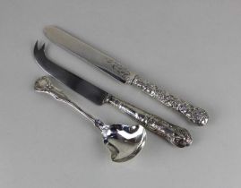 A Victorian silver butter knife with an ornate decorative handle of vines and fruit merging on to