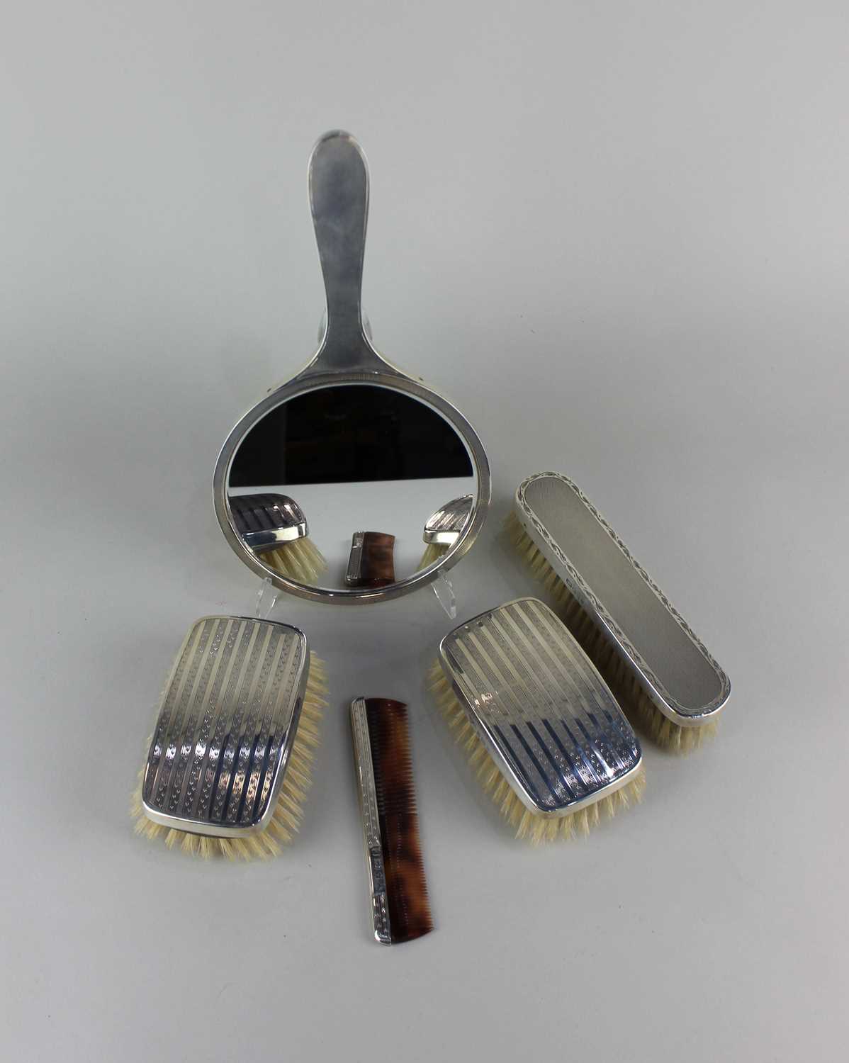 A pair of Elizabeth II silver topped clothes brushes and a matching comb, maker Garrard & Co Ltd,