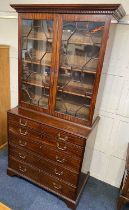 A George III mahogany secretaire bookcase with dentil carved cornice, two panel glazed doors