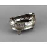 A George III silver oval dish embossed with fruit and foliage on sprayed bracket feet with later