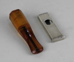 A Solingen 900 silver cigar cutter and an amber coloured cigar holder