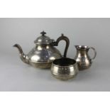 A George V silver three piece tea set of teapot, milk jug and sugar bowl, circular squat form with