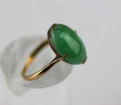 A gold ring claw set with an oval jade, detailed '18k', ring size O, gross weight 3.8g