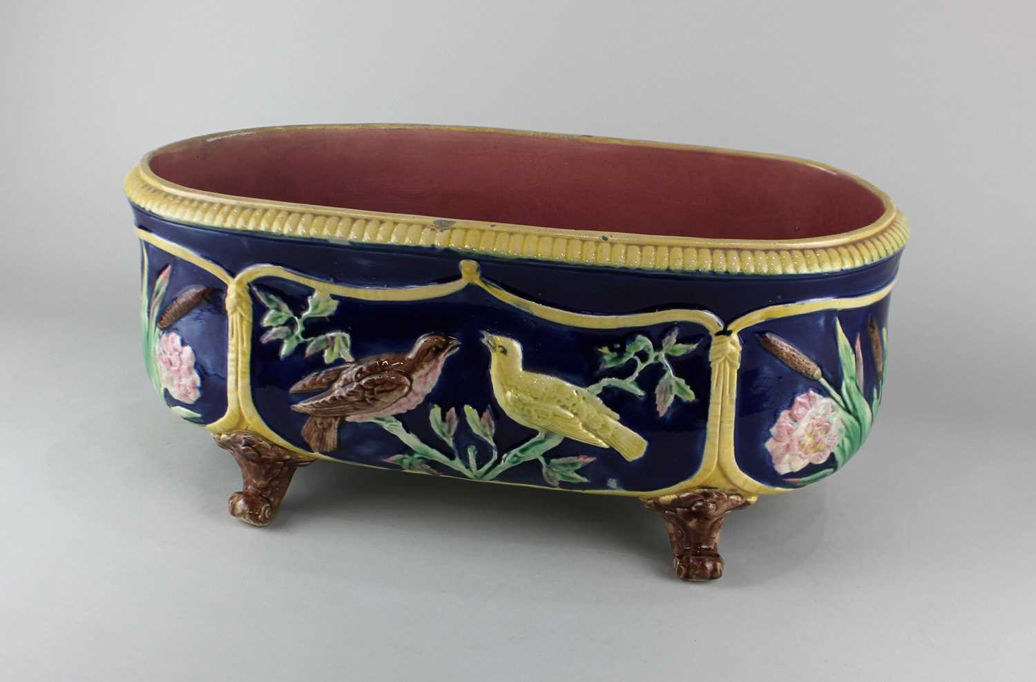A 19th century majolica jardiniere / planter, being of oval form raised on 4 scrolled feet,
