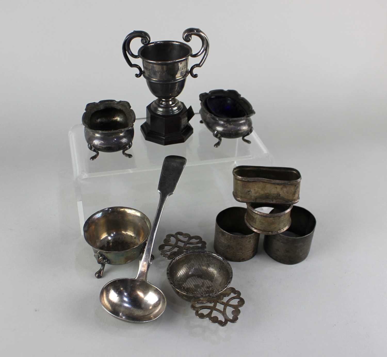 A modern silver tea strainer and stand pair of oval cruets (one with blue glass liner), a small