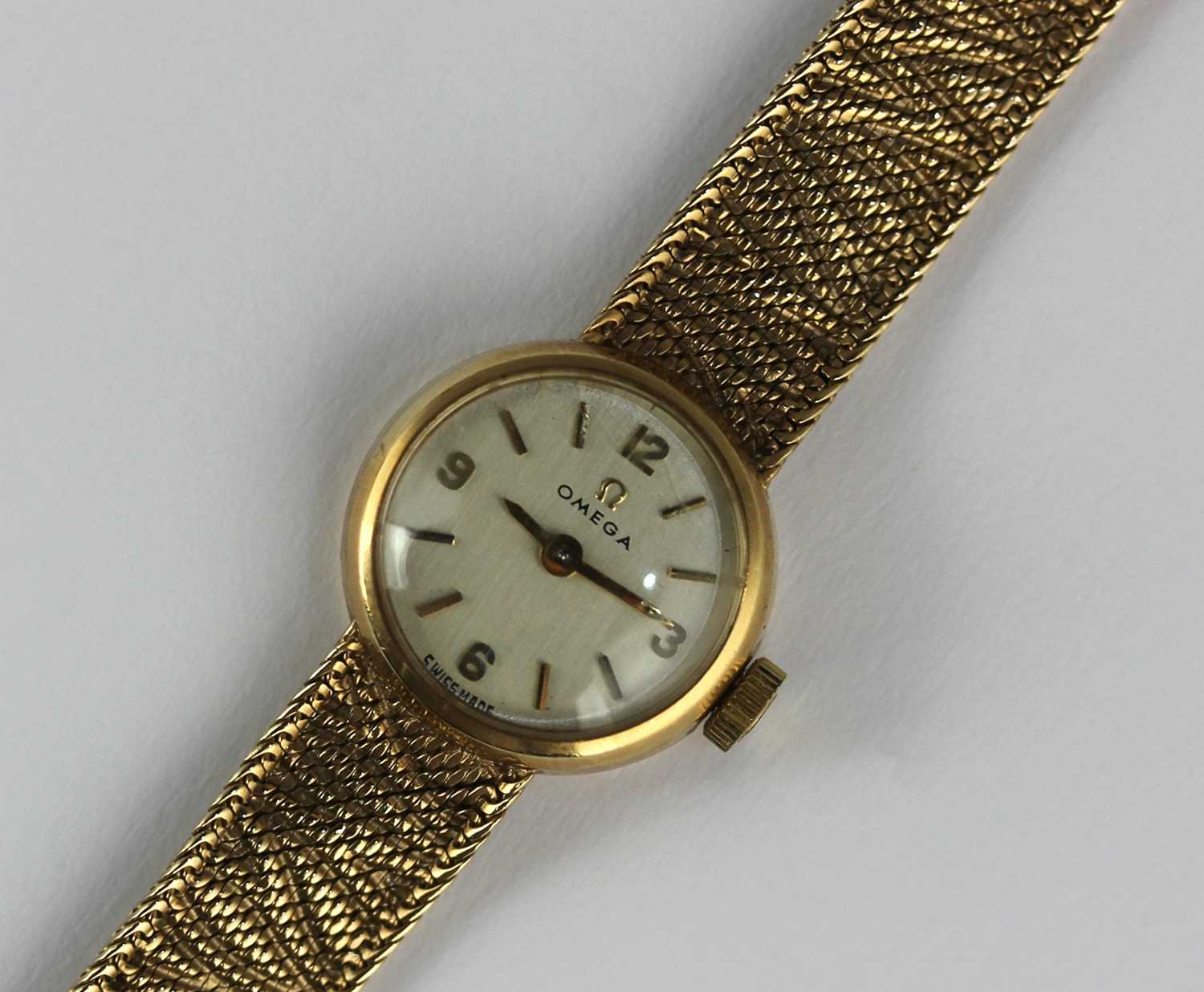 An Omega 9ct gold lady's bracelet wristwatch, the signed silvered dial with gilt Arabic and baton