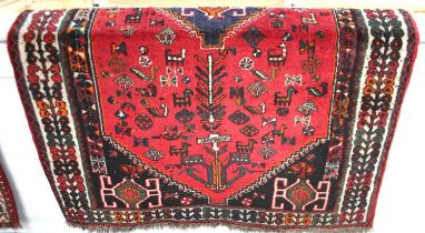 A Persian rug, red ground with central diamond-shaped medallion within a field of stylised