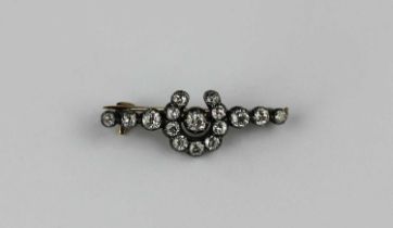 A gold backed and silver set diamond brooch with a central horseshoe motif mounted with cushion