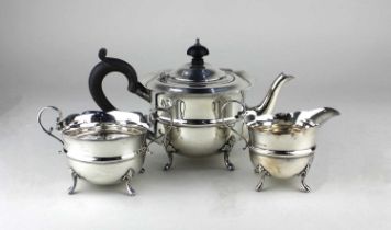 A George V silver three piece tea set of teapot, milk jug and sugar bowl, circular form with
