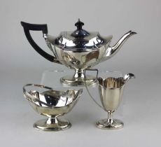 An Edward VII silver three piece tea set of teapot, sugar basket and milk jug, oval form on pedestal