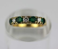 An 18ct gold emerald and diamond seven stone half eternity ring, claw set with three circular cut