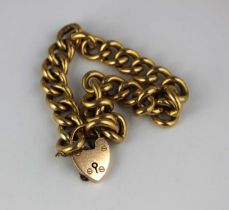 A gold hollow curb link bracelet the links detailed ‘18’, with a gold heart shaped padlock clasp
