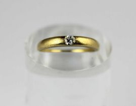A gold and diamond single stone ring mounted with a circular cut diamond detailed '18k', ring size