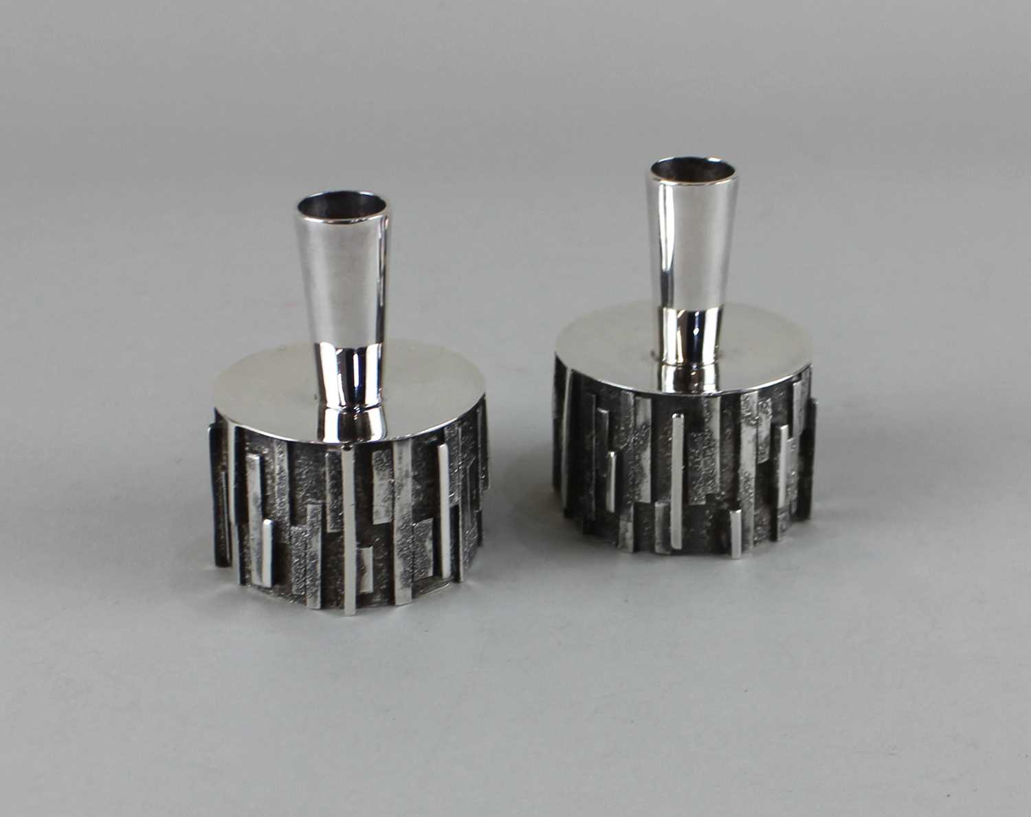 A pair of Elizabeth II silver candlesticks with tapered stems on textured cylindrical bases, maker