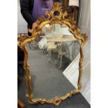 A Louis XV style giltwood cartouche shaped wall mirror, with pierced scrolling foliate decorated
