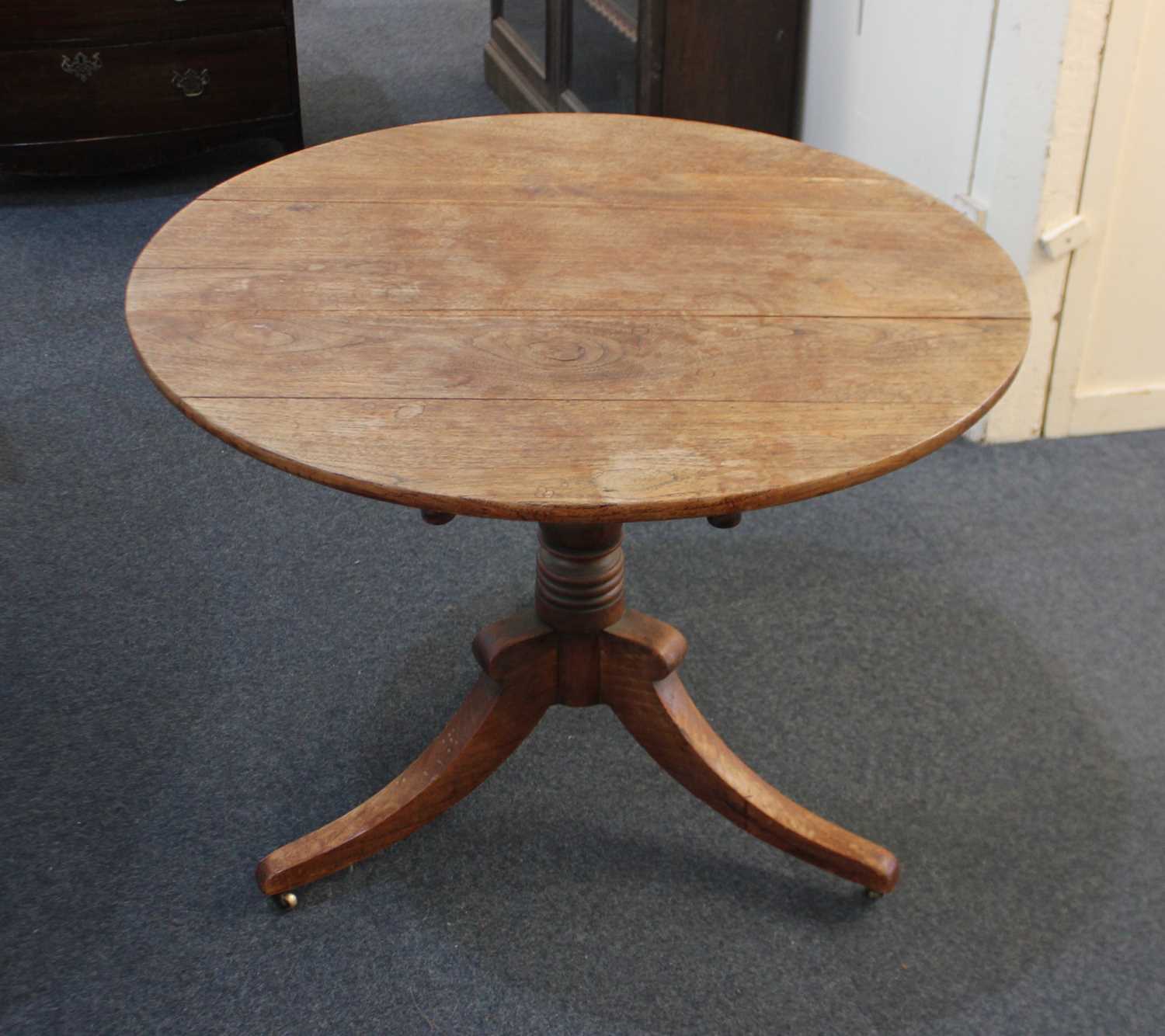 A George III circular tilt top table on turned baluster stem and tripod base, (a/f) 91cm