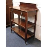 An Edwardian mahogany three tier buffet, c.1900, having a low raised back above frieze drawer