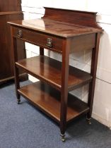 An Edwardian mahogany three tier buffet, c.1900, having a low raised back above frieze drawer