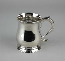 A late George II silver mug, of baluster form, with a scrolling handle, raised on a circular foot,