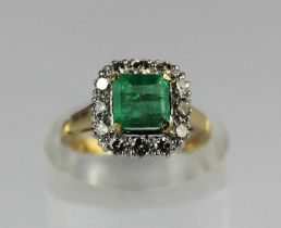 A gold, emerald and diamond cluster ring claw set with the cut cornered rectangular step cut emerald