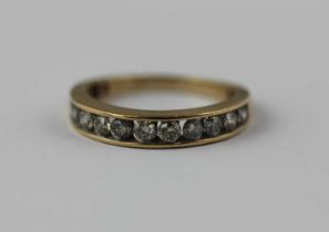 A 9ct gold and diamond eleven stone half eternity ring mounted with circular cut diamonds, ring size