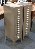 A pair of vintage industrial metal filling cabinets of small proportions, each in grey finish and