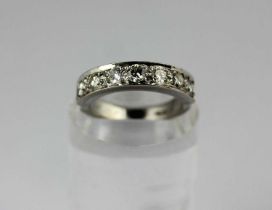 A white gold and diamond seven stone half eternity ring mounted with a row of circular cut