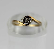 A 9ct gold and diamond two stone ring claw set with circular cut diamonds in a crossover design,