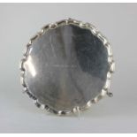 A George V silver salver with pie crust border, engraved inscription, on three hoof feet, maker