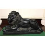 A cast bronze model of a recumbent lion 53cm